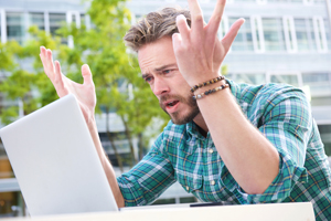 Young Man frustrated looking at his computer